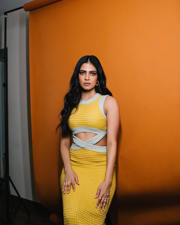 Her dress features a cut out pattern giving a glimpse of her toned abs and curves.