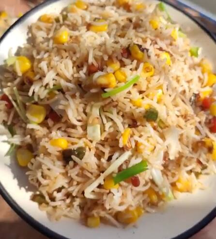தேவையான பொருட்கள் : பாஸ்மதி அரிசி - 1 கப் (30 நிமிடம் ஊறவைத்தது), ஸ்வீட் சோளம் - 1 கிண்ணம் வேகவைத்தது, எண்ணெய் - 3 மேசைக்கரண்டி, பூண்டு - 1 மேசைக்கரண்டி நறுக்கியது, வெங்காயம் - 1 நறுக்கியது, பச்சை மிளகாய் - 2 நறுக்கியது, பச்சை குடைமிளகாய் - 1/2 கப் நறுக்கியது, சிவப்பு குடைமிளகாய் - 1/2 கப் நறுக்கியது, உப்பு, மிளகு தூள் - 1 தேக்கரண்டி, சோயா சாஸ் - 2 தேக்கரண்டி, வினிகர் - 2 தேக்கரண்டி, வெங்காயத்தாள்.