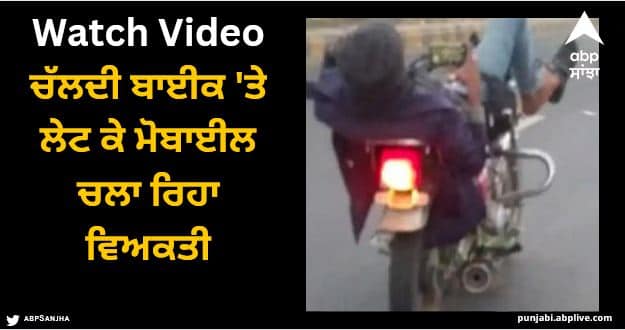 man using mobile while lying on moving bike video viral Viral Video: ਚੱਲਦੀ ਬਾਈਕ 'ਤੇ ਲੇਟ ਕੇ ਮੋਬਾਈਲ ਚਲਾ ਰਿਹਾ ਵਿਅਕਤੀ, ਵੀਡੀਓ ਦੇਖ ਕੇ ਹੈਰਾਨ ਰਹਿ ਗਏ ਲੋਕ