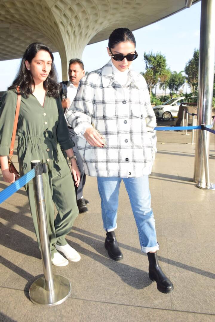 दीपिकाने  पांढरे बटण-डाउन शॅक घातले होते जे तिने ऑफ-व्हाइट हाय-नेक स्वेटर, निळे डेनिम आणि काळे बूट घातले होते.(Photo credit: Manav Manglani)