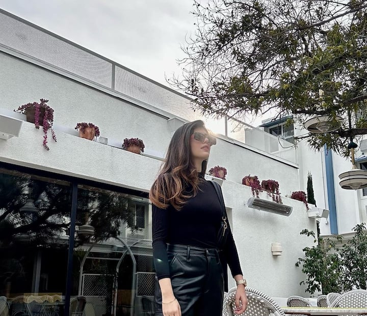 Sanjana can be seen posing in an all black outfit comprising a full-sleeve top and black pants. (Image Source: Instagram/Sanjana Sanghi)