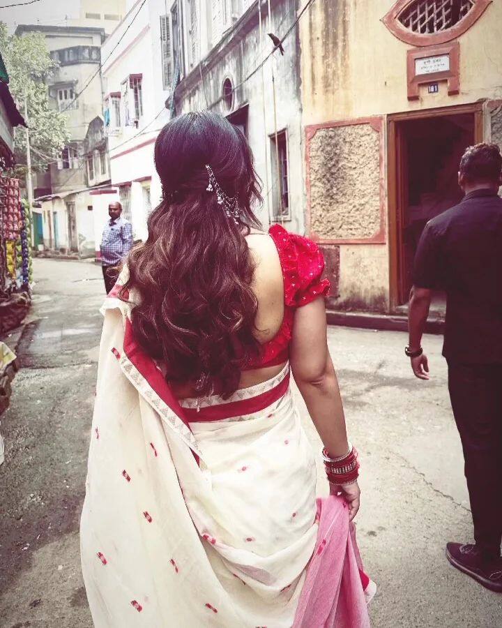 Hina also posted a photo of herself wearing the traditional red and white Bengali saree on her Instagram stories, turning backwards towards the camera.