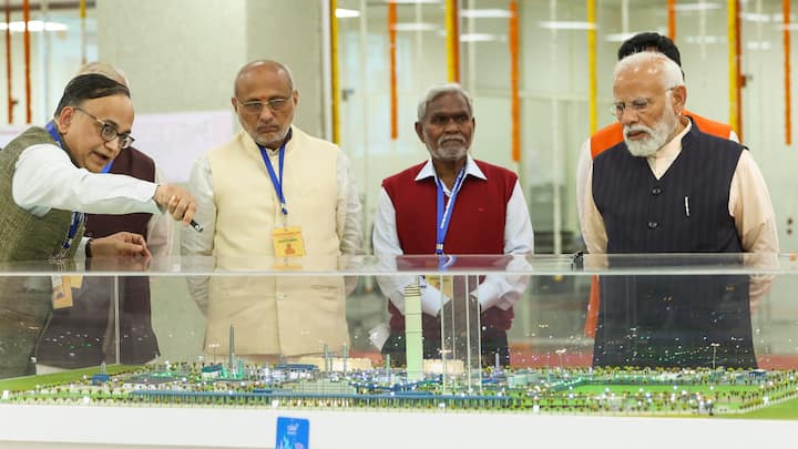 PM Modi with Jharkhand Governor C P Radhakrishnan and CM Soren inspect a model. (Photo: PTI)