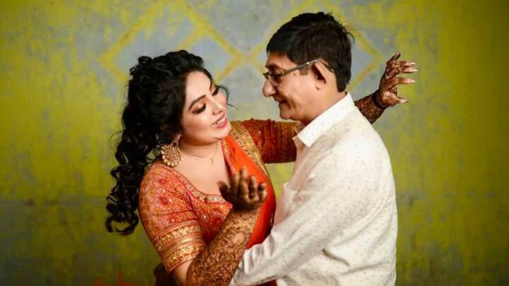 কমলা ও লালের মিশেলে ঝলমলে লেহঙ্গায় নজর কাড়লেন শ্রীময়ী চট্টরাজ। সঙ্গে সাদা শার্ট প্যান্টে কাঞ্চন। তবে শুধু কনেই নয়, ছোট্ট মেহেন্দির ছোঁয়া বরের হাতেও। ছবি: শ্রীময়ী চট্টরাজের ফেসবুক