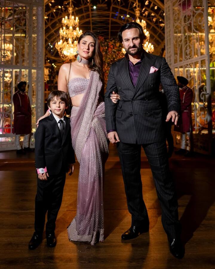 Kareena Kapoor, Saif Ali Khan, and little Taimur grab the spotlight at the grand pre-wedding event in Jamnagar. Kareena dazzles in a mauve saree with a matching corset-style blouse, complemented by minimal makeup and diamond accessories. Saif looks dapper in a striped black suit with a pop of purple, while Taimur melts hearts in a black tuxedo set. (Image source: Manav Manglani)
