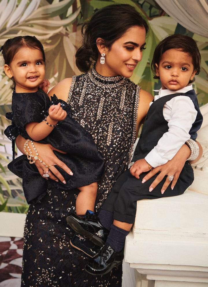 In the next picture, Isha is holding her twin children in her lap. Mommy and child are seen twinning together.