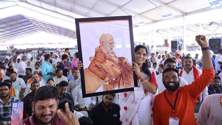 A woman showcases a handmade painting of PM Modi at Indira Priyadarshini Stadium, Adilabad.  (Photo: X/@BJP4Telangana)