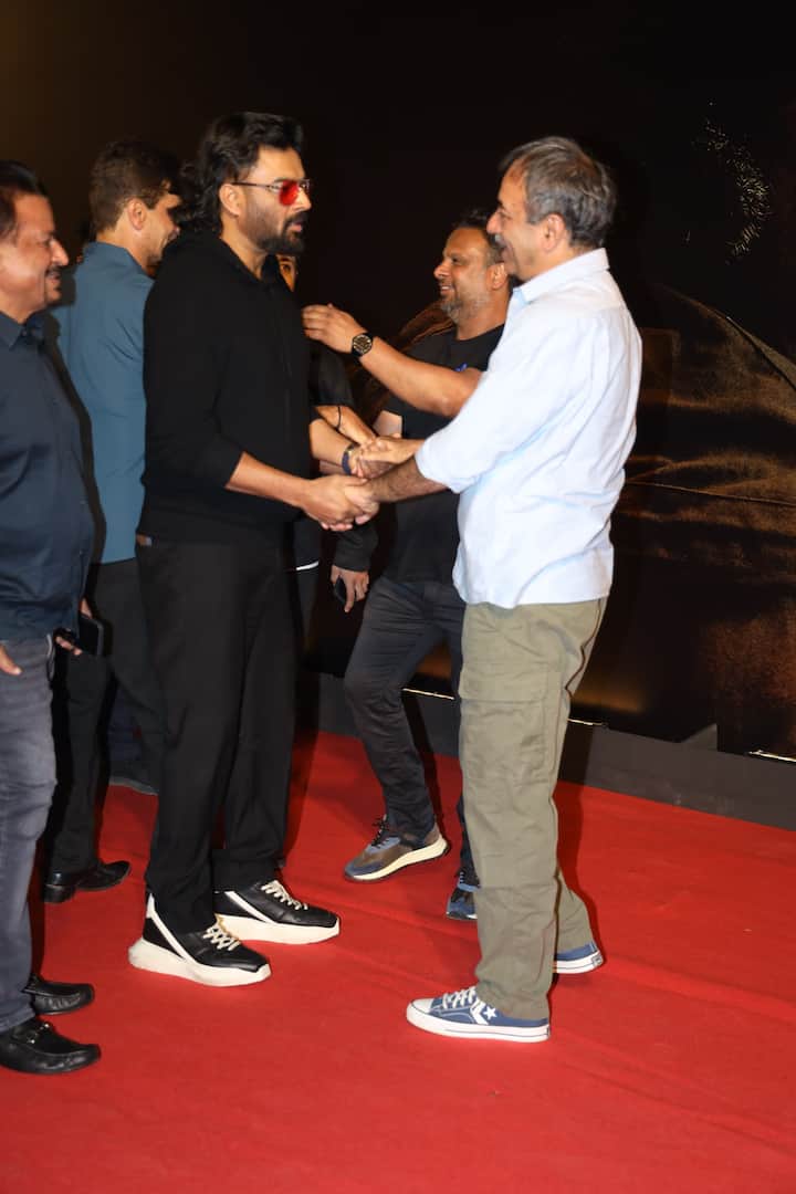 Director Rajkumar Hirani greets Madhavan as he arrives for the screening.