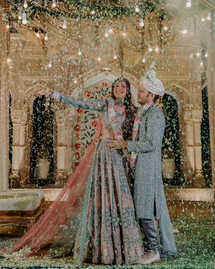 For her wedding, Surbhi wore a green and pink coloured heavily embroidery lehenga, with a matching veil. Karan opted for a matching sherwani. (Image: Instagram/@officialsurbhic)