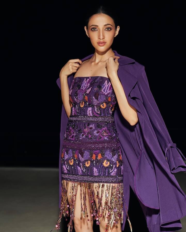 లావెండర్ మిడీ వేసుకుంది. దానికి కింద మల్టీకలర్ బీడ్స్​ను వేలాడదీశారు. ఈ మిడీపై వేసుకోవడానికి లావెండర్​ కలర్ లాంగ్ బ్లేజర్​ వచ్చింది. ఈ ఔట్​ఫిట్​ను నేహా చాలా అందంగా క్యారీ చేసింది.(Images Source : Instagram/Neha Shetty)