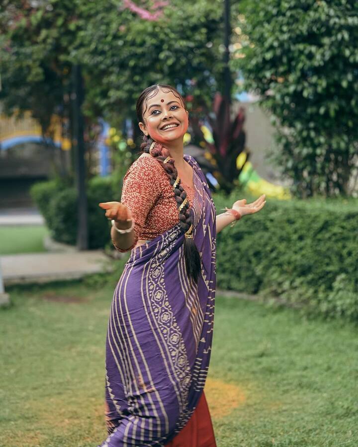 इन तस्वीरों में देवोलीना भट्टाचार्जी बंगाली बाला बनी दिखाई दे रही हैं. एक्ट्रेस ने पर्पल कलर की प्रिंटेड साड़ी पहनी है. जिसे उन्होंने रेड ब्लाउज के साथ कैरी की.