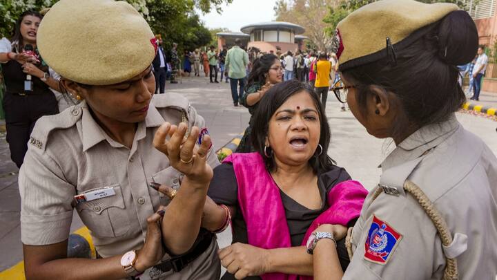 AAP worker detained during a protest outside Patel Chowk metro station. (Photo: PTI)