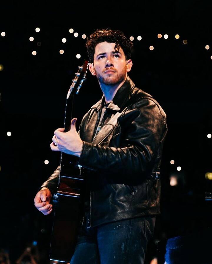 மின்னொளிகளுக்கு இடையே கிடார் வாசிக்கும் நின் ஜோனஸ்..