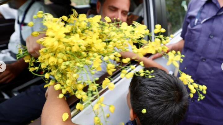 A boy hands Rahul Gandhi a bunch of flowers during his roadshow in Wayanad. (Photo: Instagram/@rahulgandhi)