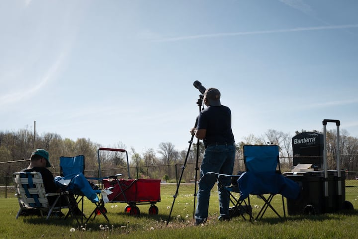 People gather in a field on the campus of Southern Illinois University to prepare for the start of the total eclipse on April 08, 2024 in Carbondale, Illinois. (Getty Image)