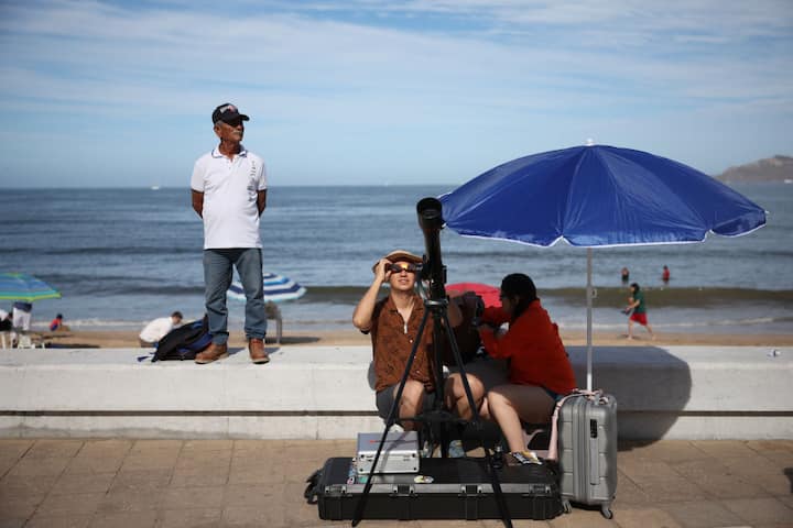 People prepare their telescope to see the eclipse on April 08, 2024 in Mazatlan, Mexico.