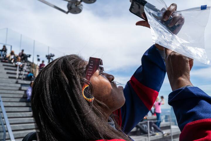 A person uses their phone at Edge at Hudson Yards before a partial solar eclipse on April 08, 2024 in New York City. (Getty Image)