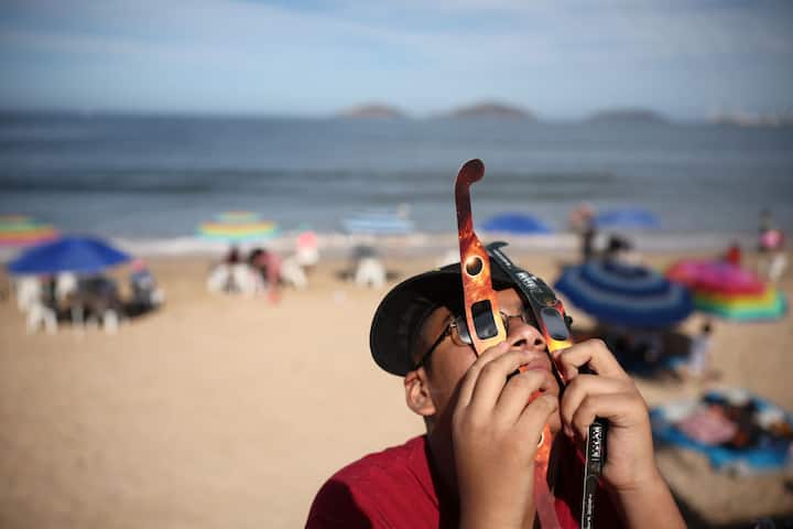 A person uses two sets of glasses to see the eclipse on April 08, 2024 in Mazatlan, Mexico. (Getty Image)