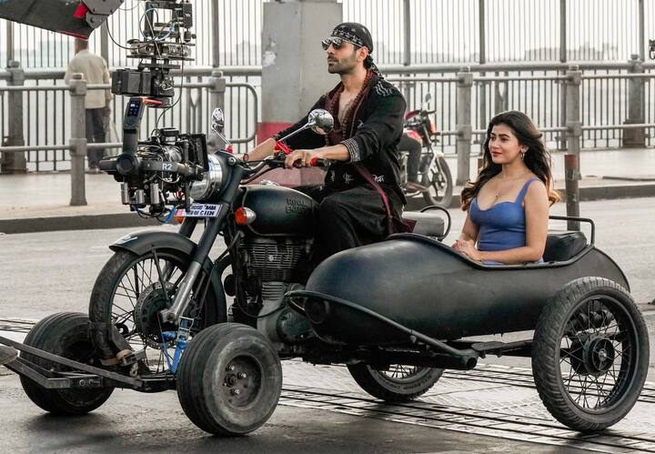 इसी बीच अब फिल्म की शूटिंग से कुछ तस्वीरें सामने आई हैं, जो खूब चर्चा में बनी हुई हैं. वायरल हो रही इन तस्वीरों में कार्तिक कोलकता की सड़कों पर तीन पहियों वाली बाइक राइड का मजा लेते हुए नजर आ रहे हैं.