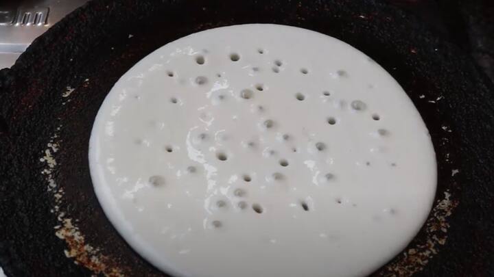 ஒரு மிக்ஸி ஜாரில் ஒரு கப் ரவை சேர்க்கவும், இதனுடன் துருவிய முக்கால் கப் தேங்காய், 5 சின்ன வெங்காயம், ஒரு ஸ்பூன் சீரகம், தேவையான அளவு உப்பு, ரவையை அளந்த கப்பால் ஒரு கப் தண்ணீர் சேர்க்கவும்.