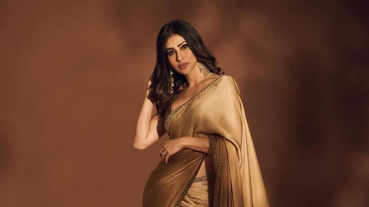Actor Mouni Roy stuns in a radiant gold saree showcasing timeless elegance and ethnic style.