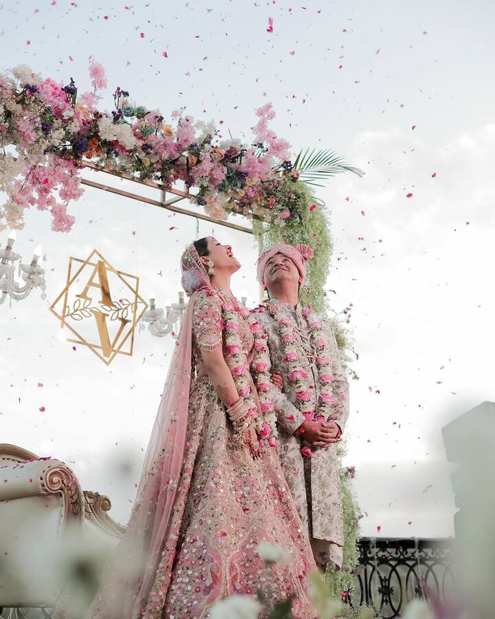 In a photo, Arushi Sharma and Vaibhav Vishant are seen standing on a stage decorated with flower petals.