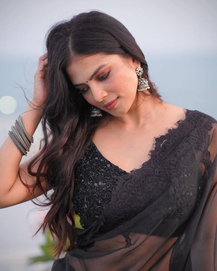 She left her hair styled open into soft waves with mid parting.