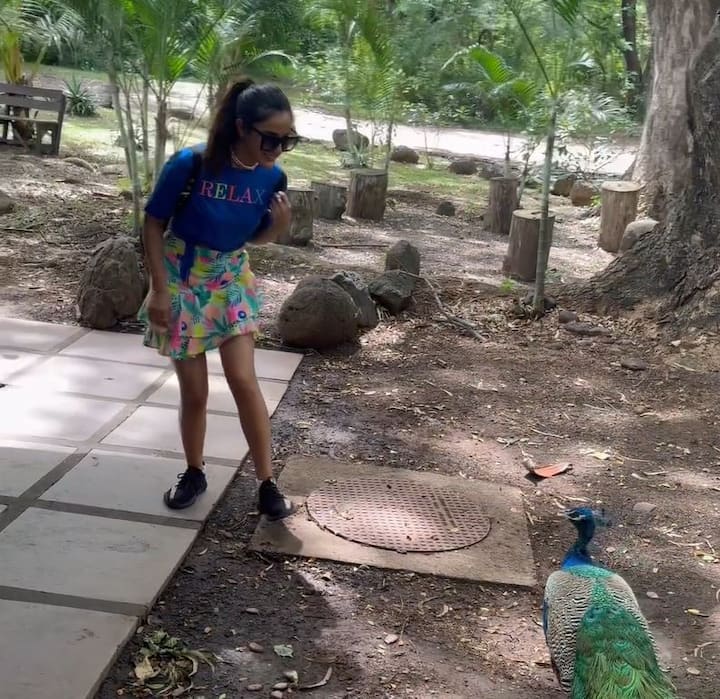 The actress is dressed in a blue T-shirt paired with a floral mini skirt.