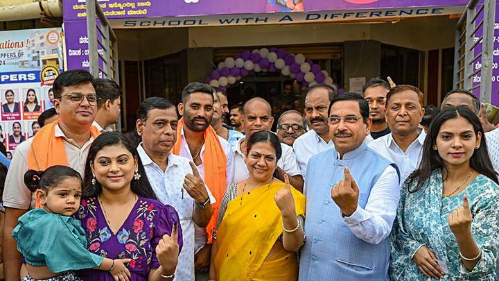 BJP leader Pralhad Joshi and his family members show their inked fingers after casting their votes in Hubballi. (image source: PTI)