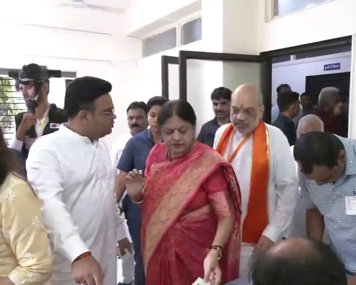 అహ్మదాబాద్ పోలింగ్ కేంద్రంలో ఓటేసేందుకు క్యూలో నిల్చున్న అమిత్ షా కుటుంబం
