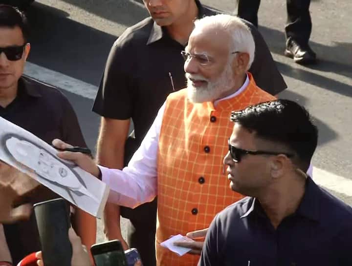 ఓటు వేసిన అనంతరం అభిమాని చిత్రించిన తన ఫోటోను చూస్తోన్న మోదీ