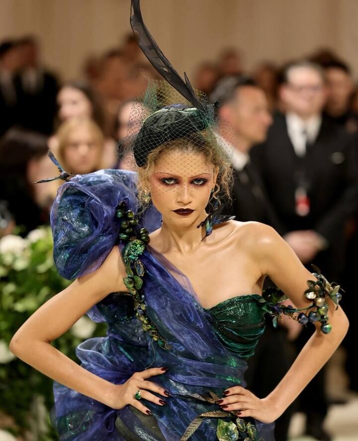 ज़ेंडया की अविश्वसनीय फैशन समझ और अद्भुत पहनावे ने उन्हें मेट गाला 2024 में बेस्ट ड्रेस की कैटेगरी में शामिल कराया. एक्ट्रेस ने 1996 के काले जॉन गैलियानो गिवेंची गाउन में शानदार एंट्री की. उन्होंने अपने लुक को शानदार ढंग से सिर पर फूलों के एक भव्य गुलदस्ते के साथ पूरा किया, जो 'गार्डन ऑफ टाइम' थीम को पूरी तरह से दर्शाता है.