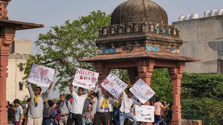 रोड शो के दौरान आप समर्थक सीएम केजरीवाल के समर्थन में पोस्टर दिखाते हुए।  (छवि स्रोत: पीटीआई)