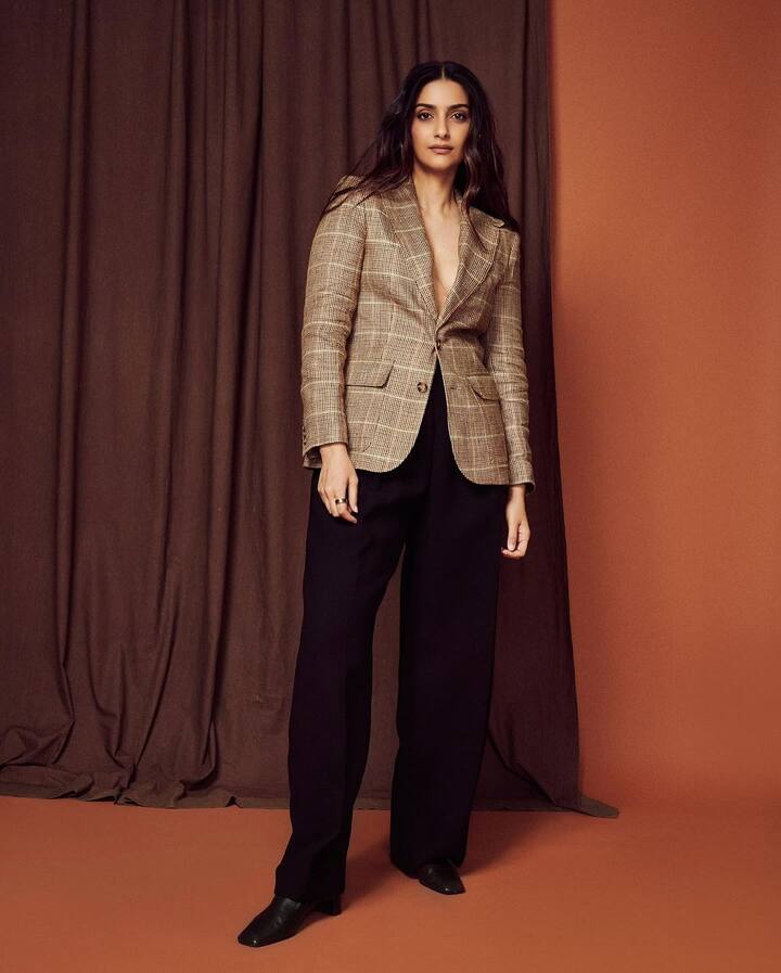 She teamed up the blazer with a pair of black baggy front pleated pants. 