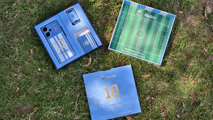 Those World Cup Touches In The Box - The interior of the package is more classy. Opening the box reveals a large blue card with Redmi and the number 10, which is a clever touch. The number 10 reflects 10 years of Xiaomi in India but is also the number worn by Argentina superstar and football legend Lionel Messi, who we suspect cannot be mentioned directly due to contractual reasons. Flip the card and you get a photograph of the team members celebrating the World Cup win, along with team member names, and Argentina's notable victories. Below this card are the phone, the charger and the charging cable, all of them in Argentina's colours. There's even a sim extractor pin with an AFA logo on one side and a football on the other. Cool!