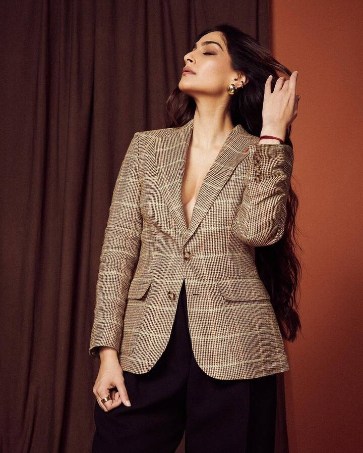 Sonam’s ensemble features a single-breated blazer with plaid check pattern, and buttoned cuffs.