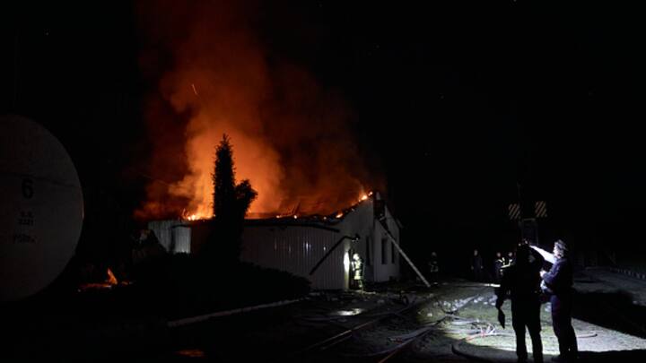 Emergency services inspected an area, as the administrative building fire burns in the background following the drone attack on Kharkiv, Ukraine. (Photo: Getty)