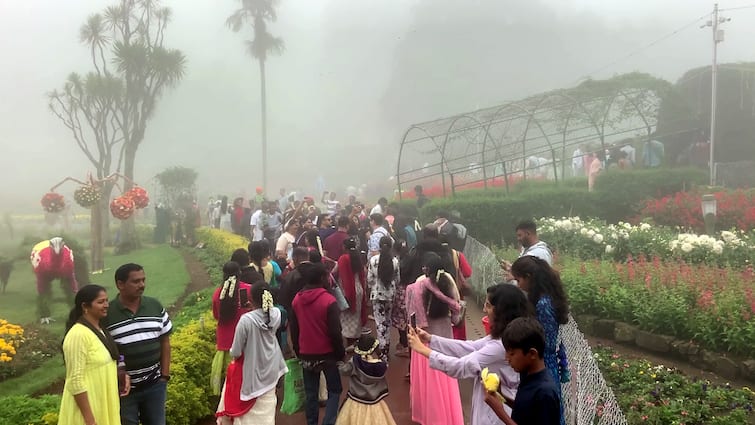 Tourists enjoying the flower show in the pouring rain at Kodaikanal. கொடைக்கானலில் கொட்டும் மழையில் மலர் கண்காட்சியை ரசிக்கும் சுற்றுலா பயணிகள் ..