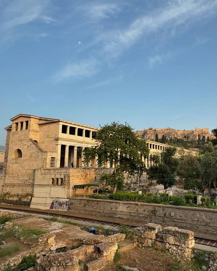 The couple is posing against the beautiful historical landscape of Athens.