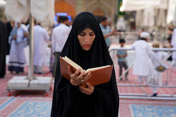 A Shiite mourner reads religious text at Imam Ali shrine in the central Iraqi holy city of Najaf. (Photo: Getty)