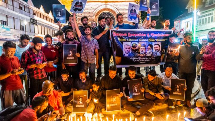 Kashmir residents hold pictures of Raisi during a vigil held in his memory on Monday night in Srinagar, Jammu & Kashmir. (Photo: Getty)