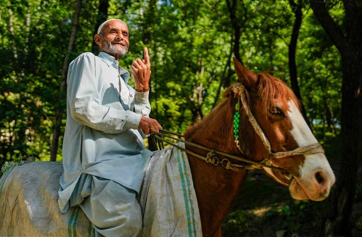 दक्षिण कश्मीर के कुलगाम जिले के नंदीमार्ग इलाके में लोकसभा चुनाव के छठे चरण के दौरान एक मतदान केंद्र पर वोट डालने के बाद एक बुजुर्ग व्यक्ति अपनी स्याही लगी उंगली दिखाता हुआ, शनिवार, 25 मई, 2024। (स्रोत: पीटीआई)