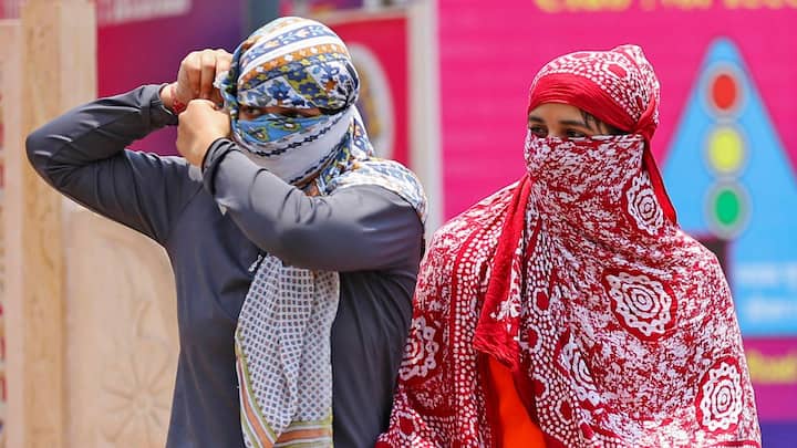 जयपुर में धूप से खुद को बचाती महिलाएं। (छवि स्रोत: पीटीआई)