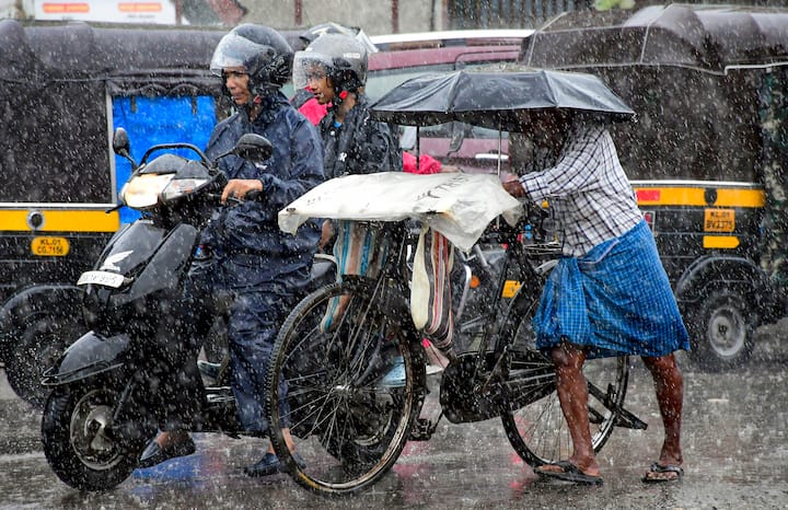 बुधवार, 29 मई, 2024 को तिरुवनंतपुरम में बारिश के दौरान सड़क पर चलते यात्री। (स्रोत: पीटीआई)
