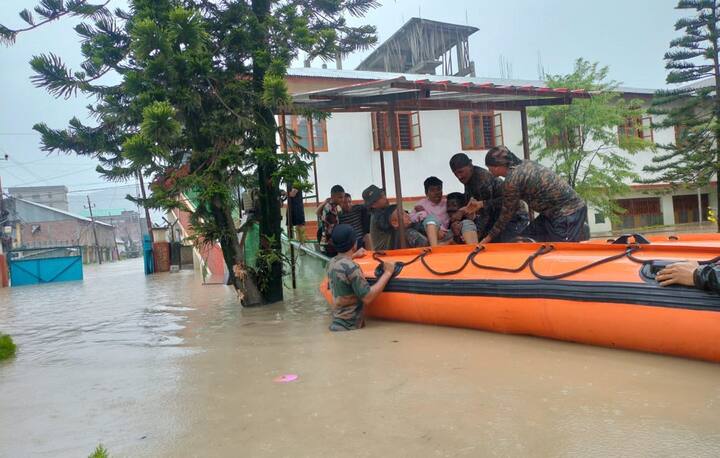 इम्फाल शहर में चक्रवात रेमल के बाद बाढ़ प्रभावित क्षेत्र में जलतरंग बचाव एवं राहत अभियान के दौरान असम राइफल्स के जवान अन्य लोगों के साथ। (स्रोत: पीटीआई)