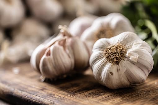 Garlic (Allium sativum): Garlic, with its pungent taste and heating nature, helps stimulate digestion and expel toxins from the body, reducing inflammation and alleviating arthritis discomfort. (Image Source: Getty)