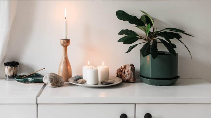 1. Layered Heights: For a chic, designer look, place candles of varying heights together. This creates an interesting visual effect and allows the light to spread more dynamically. Use candle holders or stands to elevate some candles, adding layers and dimensions to your display. (Image Source: Canva)