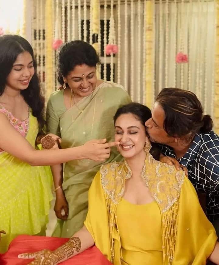 Like the Haldi ceremony, Aishwarya also posed with her family at the Mehndi ceremony. In this photo, while father Arjun is kissing him, sister Anjama and mother are seen showering love on him.
