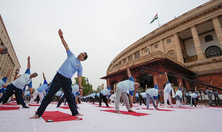 People perform yoga on the occasion of the 10th International Day of Yoga, at the Parliament House complex, in New Delhi. (Image Source: PTI)