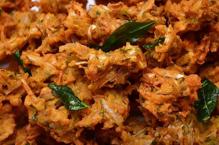 அதன் பின் முட்டைகோஸ் கலவையை சூடான எண்ணெயில் தூவிவிடவும். ஒரு இடத்தில் தூவி விடாமல் நாலா புறமும் முட்டைகோஸை பரப்பி விடவும்.